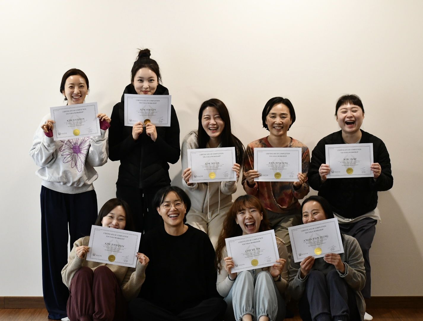스티라요가 인요가 워크샵 수료증을 들고 함께 웃는 참가자들